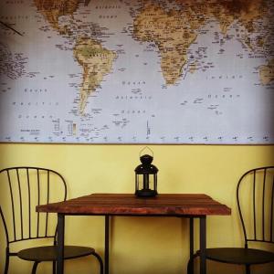 加埃塔米勒夸特罗森托住宿加早餐旅馆的一张桌子和两把椅子,墙上有一张世界地图