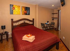 阿拉胡埃拉梅尔罗斯机场住宿加早餐旅馆的一间卧室配有红色的床和毛巾