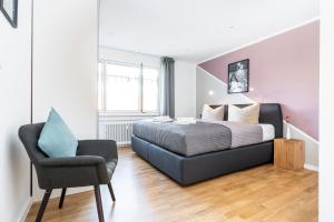 弗莱堡Deluxe Apartments Friedrichstrasse的一间卧室配有一张床和一把椅子