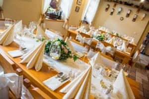 LibuňPenzion Restaurace u Helferů的用餐室配有带白色桌布和玻璃杯的桌子