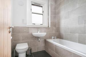 达尔基斯Dalkeith Three Bed Two Bath Apartment的浴室配有卫生间、盥洗盆和浴缸。