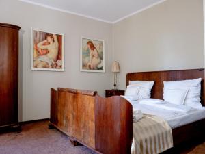 希维博津兰尼夫卡的一间卧室配有一张木床,墙上挂有两张照片