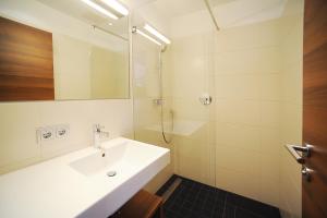 因斯布鲁克Seehof Innsbruck的白色的浴室设有水槽和淋浴。