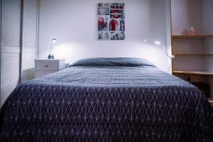 奥利沃斯Deptis的一间卧室配有一张带紫色棉被的床