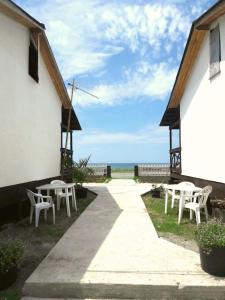 阿拉克哈济Солнечный Берег的一个带白色桌椅的庭院和大海