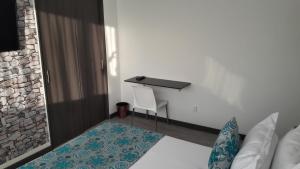 马尼萨莱斯Hotel Rosales Plaza的一间卧室配有书桌、一张床和一张桌子