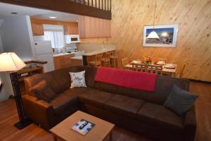 斜坡村塔霍俱乐部度假酒店的一间带棕色沙发的客厅和一间厨房