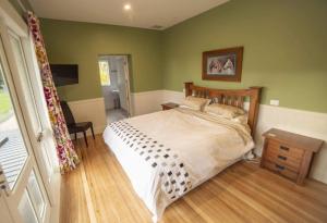 WaiparaWaipara River Estate的一间卧室设有一张带绿色墙壁的大床