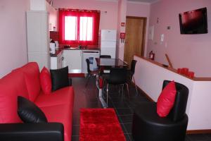坎普自由鎮Vila Centro的客厅配有红色的沙发和桌子