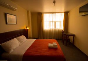 帕卡斯马约El Puerto Hotel的酒店客房设有床和窗户。