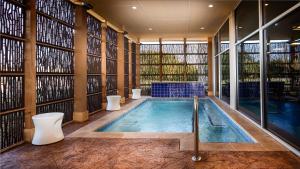 迪索托GLō Best Western DeSoto Dallas的一个带两个卫生间的游泳池和一个大窗户的大房间