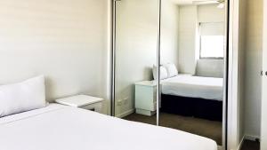 汤斯维尔Oaks Townsville Gateway Suites的小房间设有两张床和镜子