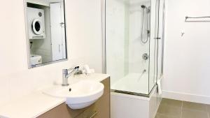 汤斯维尔Oaks Townsville Gateway Suites的白色的浴室设有水槽和淋浴。