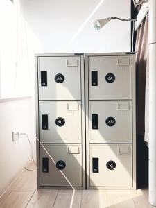 高雄AHIRUYAH鸭家青年旅馆 的两个金属文件柜,放在一个有灯的房间