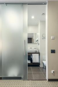 阿斯塔纳Comfort Hotel Astana的浴室设有滑动玻璃门和水槽