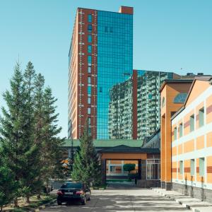 阿斯塔纳Comfort Hotel Astana的一座高楼前的停车场