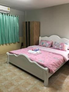 合艾Pani House Hatyai 1的一间卧室配有一张带粉色床单和枕头的床。