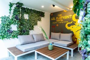 曼谷The LOL Elephant Hostel的一间设有两张沙发和一面绿色墙壁的客房