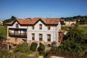 潘多尔雷斯La Vega de Pendueles的一座位于山上的白色大房子,设有阳台