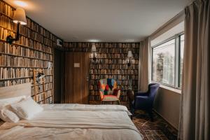 塞格德Aquapark Design Rooms的一间卧室配有床、椅子和书籍