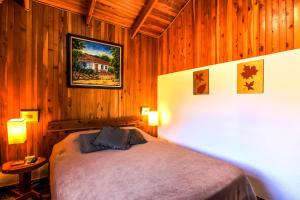 格雷西亚芒果谷酒店的卧室配有木墙内的一张床