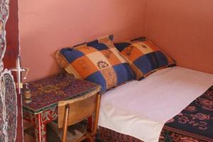 马拉喀什爱德酒店的一间小卧室,配有一张床和一张桌子