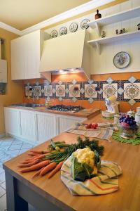 萨莱诺Donna Filomena Casa Vacanza di Charme的厨房里放着胡萝卜和其他蔬菜在桌子上