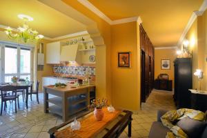萨莱诺Donna Filomena Casa Vacanza di Charme的厨房和带黄色墙壁及桌子的客厅