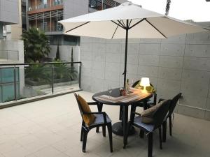 ChirivellaLoft with terrace 24m2, swimming pool and garage的阳台配有桌椅和遮阳伞