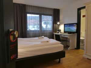 诺斯罗驰菲尔德伯克餐厅酒店的一间卧室配有一张床和一张带电脑的书桌