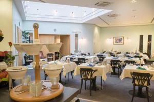鲁尔河畔米尔海姆米尔海姆论坛贝斯特韦斯特酒店的一间设有白色桌椅的用餐室