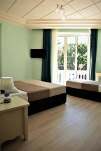 都拉斯Hotel Veliera的一间卧室设有两张床和大窗户