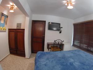 圣多明各高特罗迈松酒店的卧室配有一张床,墙上配有电视。