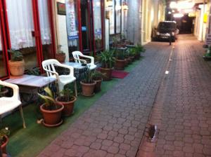 萨姆松纳契米酒店的一条街道,街道上摆放着桌椅和盆栽植物