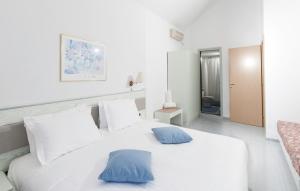 林都斯威乐迪林德斯酒店的一张带两个蓝色枕头的白色床