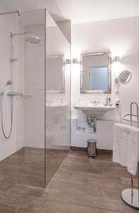 韦斯特兰美丽华酒店的一间带玻璃淋浴和水槽的浴室