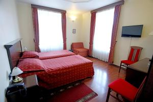 萨莫博尔Hotel Lavica的一间卧室配有红色的床和电视