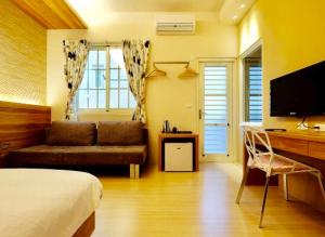 花莲市普立堤民宿 的一间卧室配有一张床和一张书桌及电视