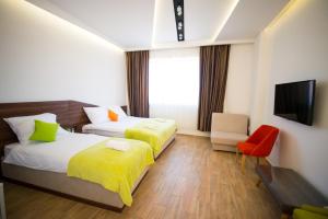 尼什Garni Hotel Apel Apartments的酒店客房设有两张床和电视。