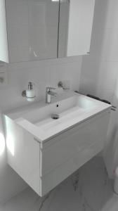 奥斯坦德Hydro Palace的白色的浴室设有水槽和镜子