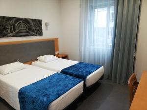 卡佩拉什Whalesbay Hotel Apartamentos的酒店客房设有两张床和窗户。