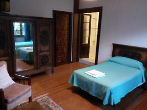 CasoHotel Rural La Lastra的一间卧室配有一张床和镜子