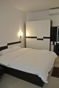 纳通市斯里兰卡岛酒店的一间卧室配有一张带白色床单的大床