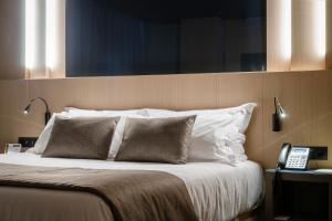 安道尔城大都会酒店的一间卧室配有一张床,旁边还有电话