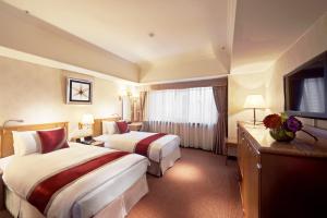 台北台北天成大饭店的酒店客房设有两张床和一台平面电视。