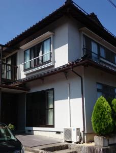 阿智村Guest house Minna no Ie的白色的房子设有窗户和阳台