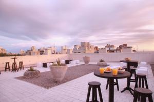 蒙得维的亚Esplendor by Wyndham Montevideo Cervantes的屋顶庭院配有桌椅,天际线