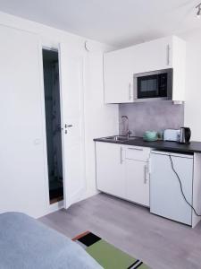 瓦尔考斯57 Kauppakatu的厨房配有白色橱柜和微波炉