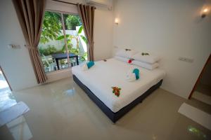 图杜Lagoon Villa Thoddoo的卧室配有白色床,拥有圣诞装饰