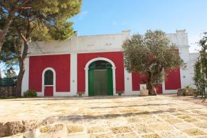 拉泰尔扎Masseria Sierro lo Greco的一座红色和白色的建筑,设有绿门